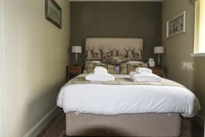 a bedroom with a large bed with two towels on it at The Sheiling in Dornie