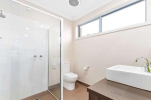 a bathroom with a shower and a toilet and a sink at Comfort Inn & Suites Warragul in Warragul