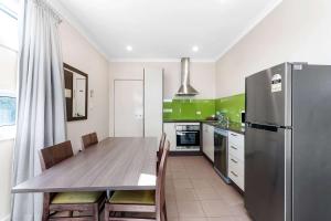 a kitchen with a wooden table and a refrigerator at Comfort Inn & Suites Warragul in Warragul