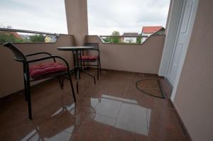 a balcony with two chairs and a table and two windows at Guest House Korita in Grabovac