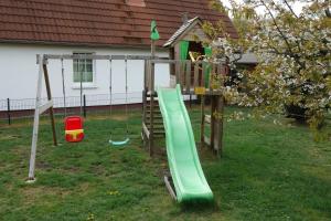 a playground with a slide in a yard at Heydens Ferienhaus_HEYD in Ostseebad Karlshagen