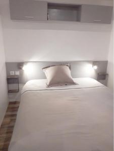 een wit bed met een wit kussen erop bij Mobile Home Service Hotelier in Fréjus