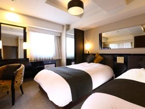 una camera d'albergo con due letti e uno specchio di APA Hotel Ningyocho-eki Kita a Tokyo
