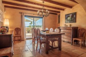 uma sala de jantar com uma mesa de madeira e cadeiras em Villa Ses Marjades em Cala Vadella