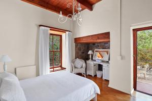 Un dormitorio con una cama y un escritorio y una ventana. en Greystones Beach House, en Langebaan