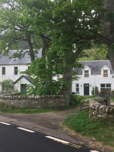 ein weißes Haus am Straßenrand in der Unterkunft Inverlael Farm Cottages in Inverlael