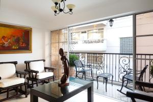a living room with a balcony with chairs and a table at Hotel La Colonia in Santo Domingo