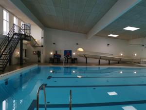 a large swimming pool with a slide in a building at Tangsø Hytteby in Bækmarksbro