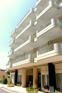 a white building with balconies on the side of it at Melissa II Hotel in Eleusis