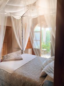 1 dormitorio con cama con dosel y ventana en Finca Galea, en Carballido