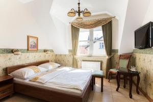 a bedroom with a bed and a tv and a window at Residenz Selena in Ustka