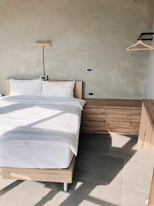 1 dormitorio con 1 cama blanca grande y espejo en Timeline cafe studio en Longjing