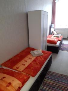 sypialnia z 2 łóżkami z czerwoną pościelą w obiekcie Ferienwohnung Hahn w mieście Sebnitz