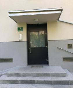 una porta nera su un edificio con scale di Castle View Studio a Lubiana