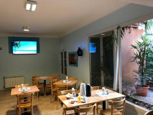 un restaurante con mesas y sillas de madera y TV en Hotel Ideal en Miramar