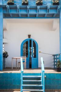 uma porta azul num edifício com uma mesa e cadeiras em El Primo Hotel Dahab em Dahab