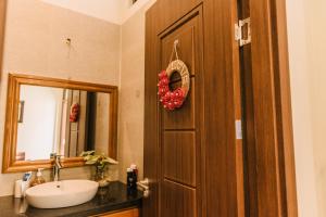 a bathroom with a sink and a door with a mirror at Chi Homestay #3 in Hue