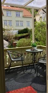 eine Terrasse mit 2 Stühlen, einem Tisch und einem Gebäude in der Unterkunft Ellingsens Apartment Egersund in Egersund