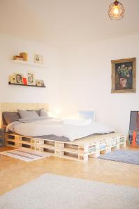 łóżko z drewnianą ramą w pokoju w obiekcie Villa Papaya w Bratysławie