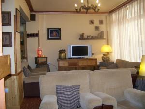 a living room with couches and a flat screen tv at Hotel Prats in Ribes de Freser
