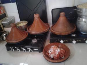 a stove with two pots and a bowl of food at Kasbah tifaoute ait Ben haddou in Aït Ben Haddou