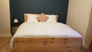 a bedroom with a large bed with white sheets at A la liberté in Salins-les-Bains