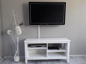 a white entertainment center with a tv on a wall at Luxury Living Apartment in Kněževes