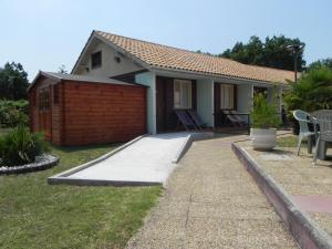a house with a patio and a fence at Hotel Les Pins in Hourtin