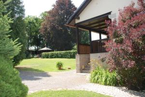 un giardino con un edificio con portico e fiori di Landhaus Gohrisch a Kurort Gohrisch