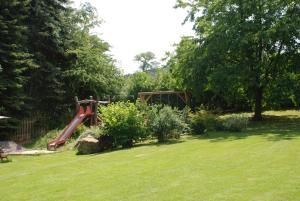 einen Spielplatz im Garten mit einer roten Rutsche in der Unterkunft Landhaus Gohrisch in Kurort Gohrisch