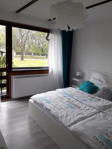a white bed in a bedroom with a large window at Luxury Living Apartment in Kněževes