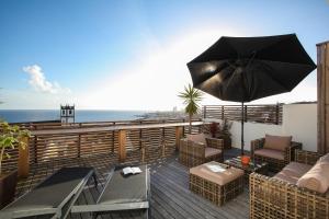 a patio with an umbrella and chairs and a table at Villa Terra in Lagoa