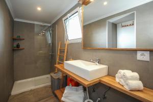 ein Badezimmer mit Waschbecken, Dusche und Spiegel in der Unterkunft Villa Terra in Lagoa