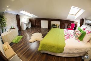 1 dormitorio con 1 cama grande con manta verde en Elegancki loft w centrum., en Augustów