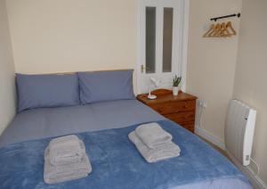 a bedroom with a blue bed with towels on it at 2 Bell Street in Talgarth +26 photos