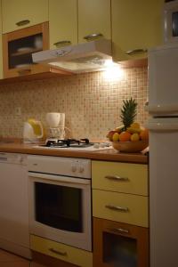 a kitchen with a stove and a bowl of fruit at Apartment Radalj in Kaštela