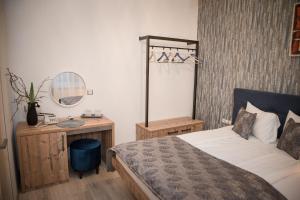 a bedroom with a bed and a table and a mirror at ART Hotel in Sibiu