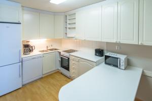 una cocina con electrodomésticos blancos y armarios blancos en Jääskän Loma Ratatie 3 asunto 6 Kauhava en Kauhava