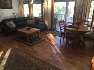 - un salon avec un canapé et une table dans l'établissement Lakeside Garden Chalet, à Denmark