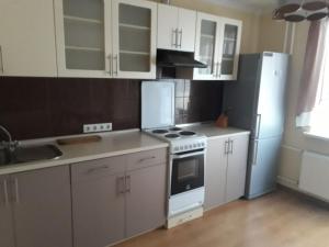 a kitchen with white cabinets and a stove and refrigerator at Center Park Brovary in Brovary