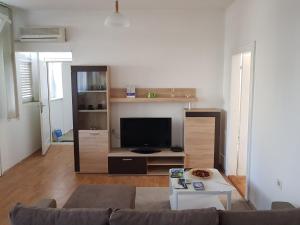 a living room with a couch and a tv at SARA Apartment in Banja Luka