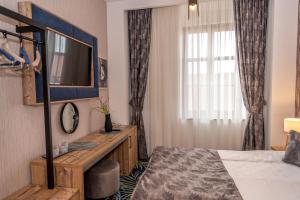 a hotel room with a bed and a television at ART Hotel in Sibiu