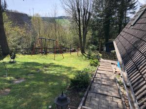 a backyard with a swing set and a playground at Eifelwolke in Kerschenbach