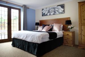 Un dormitorio con una cama grande y una ventana en Little Foxes Hotel & Gatwick Airport Parking, en Crawley