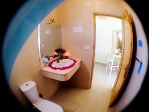 a man laying on a toilet in a bathroom at El Primo Hotel Dahab in Dahab