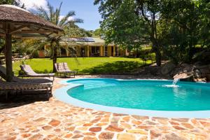 a swimming pool with a fountain in a yard at Safari Beach Lodge in Senga