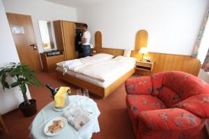 a hotel room with a bed and a chair at Hotel Cordial in Lennestadt