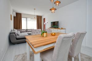 a living room with a dining room table with chairs at Apartment Grand Karavel Centre in Varna City