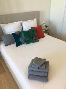 Una cama blanca con almohadas y toallas. en Bright & modern apartment in the heart of Antibes, en Antibes