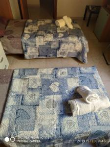 2 posti letto in camera con asciugamani sul pavimento di Alma a Porto Torres